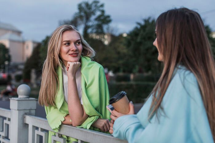 Dos mujeres conversando al aire libre al atardecer, compartiendo trucos vitales muy útiles para el día a día.