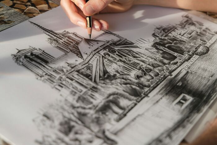 Mano dibujando a lápiz arquitectura detallada de una catedral antigua en un papel con un estilo artístico único.