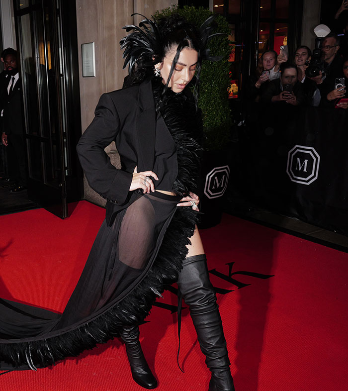 Vestido con plumas negras y botas altas en momentos incómodos ocurridos durante la Gala Met 2025 en la alfombra roja.