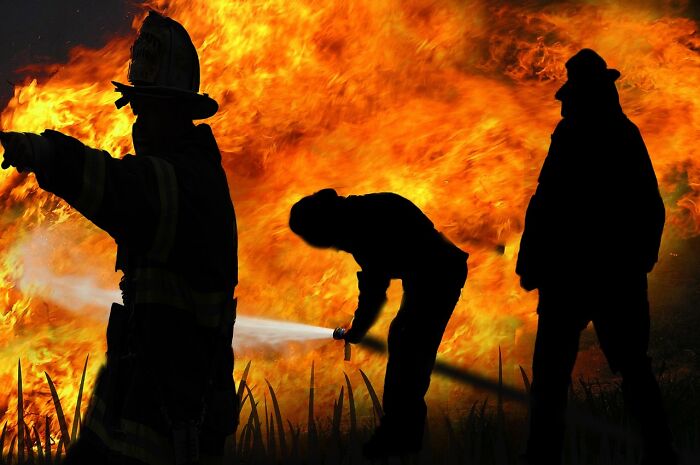 Bomberos y personal sanitario de emergencias combatiendo un incendio intenso con consejos vitales para situaciones de emergencia.