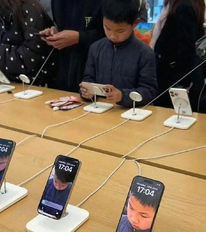 Niño jugando con un teléfono en tienda de tecnología, imagen curiosa que demuestra momento que menos mal hicieron una foto.