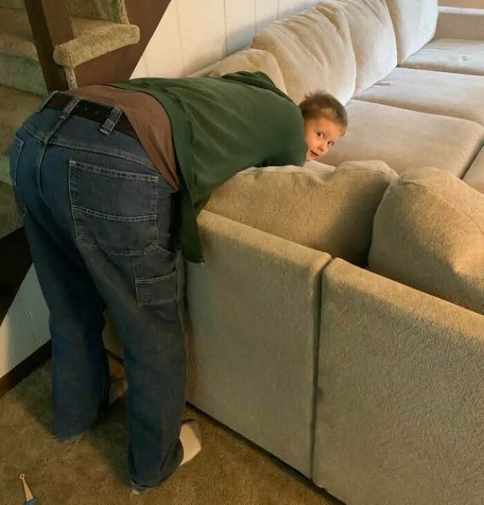 Niño juega escondido al lado de un adulto doblado, captura divertida y sorprendente en personas que menos mal hicieron una foto.