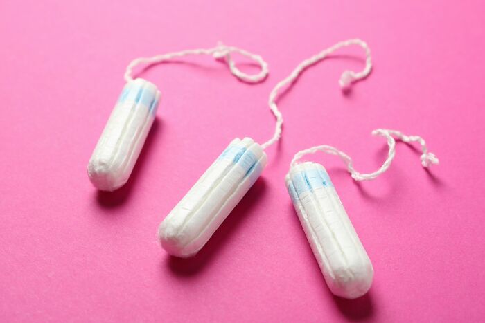 Tampón blanco con cuerda sobre fondo rosa, representación de personas bastante únicas y lote genética.