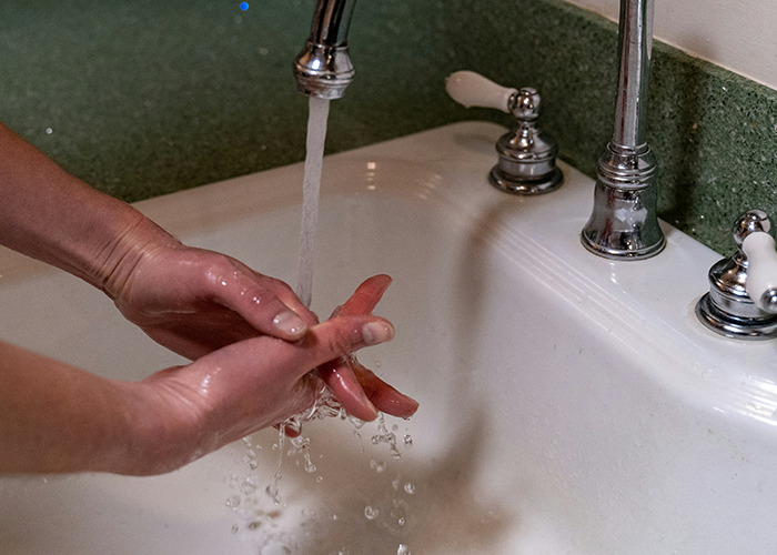 Lavado de manos cuidadoso con agua corriente siguiendo consejos vitales del personal sanitario y de emergencias.