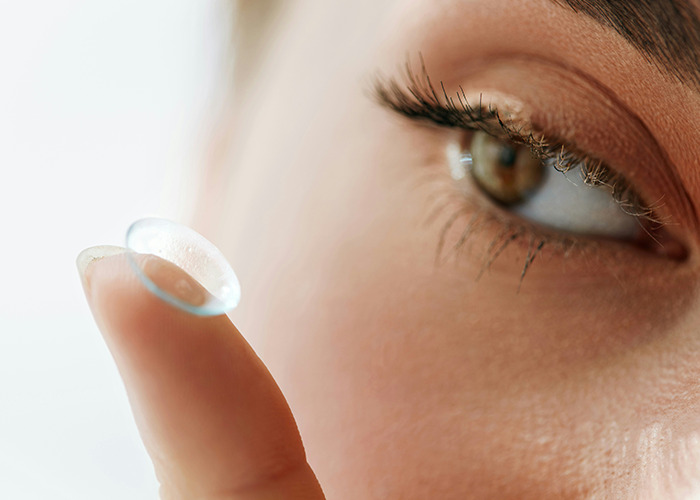 Persona colocando lente de contacto en el ojo, imagen relacionada con consejos vitales de personal sanitario y de emergencias.