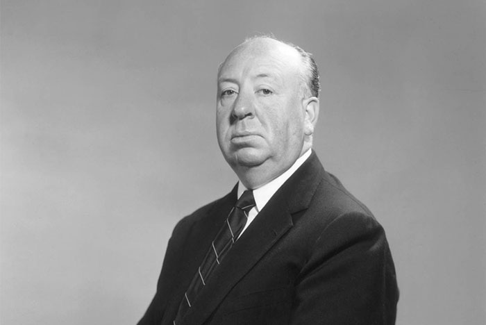 Retrato en blanco y negro de una celebridad problemática con expresión seria, vestido formal y fondo neutro.