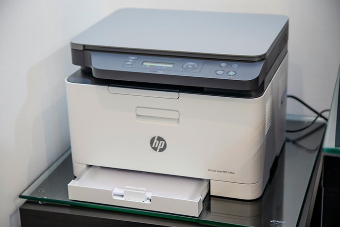 Impresora HP en oficina moderna sobre vidrio, concepto de personas que se han dado cuenta de que su pareja es idiota.