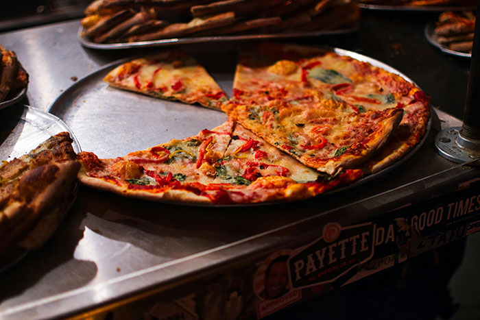 Pizza con vegetales y queso en plato, ideal para personas que se han dado cuenta de que su pareja es idiota.