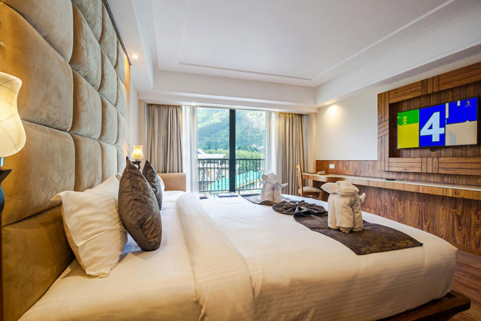 Habitación de hotel moderna con cama doble, decoración elegante y vista a montañas, vinculada a parejas que se han dado cuenta.