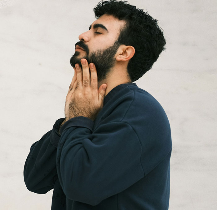 Hombre con barba y suéter azul mostrando expresión de reflexión, ilustrando parejas que se han dado cuenta de que su pareja es idiota.