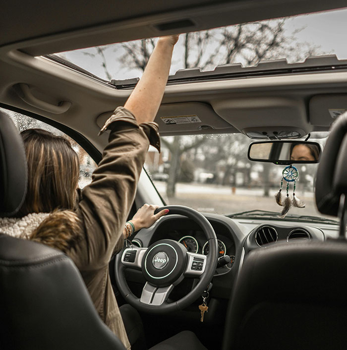 Mujer conduciendo un Jeep, usando el techo corredizo, reflejando una situación de personas que se han dado cuenta de que su pareja es idiota.