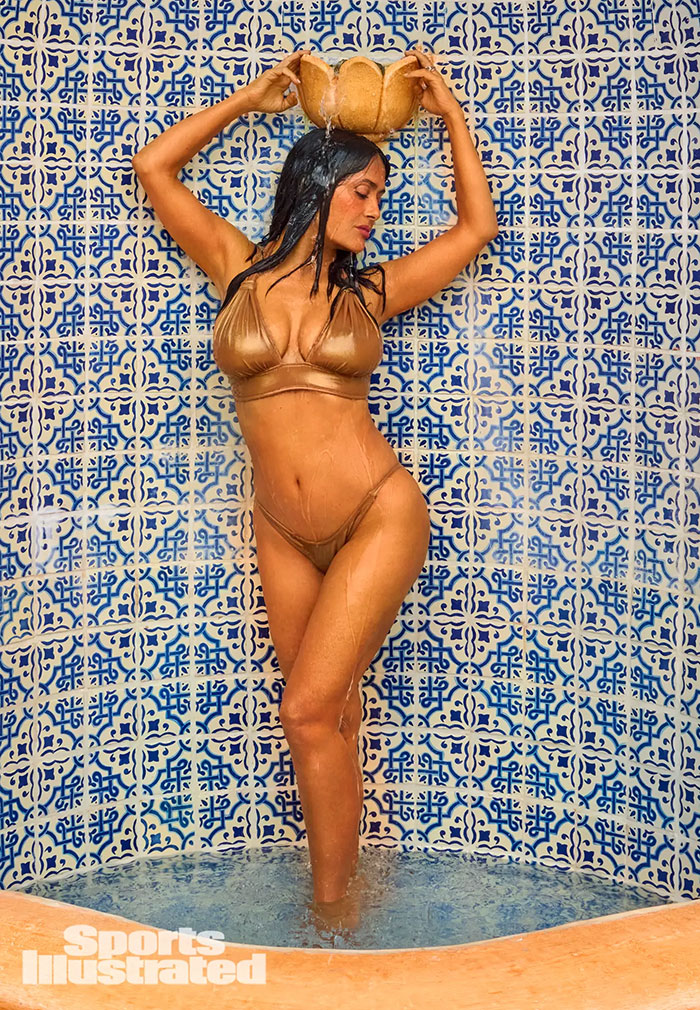 Salma Hayek en bikini dorada posa bajo agua en fuente con azulejos decorativos para Sports Illustrated Swimsuit