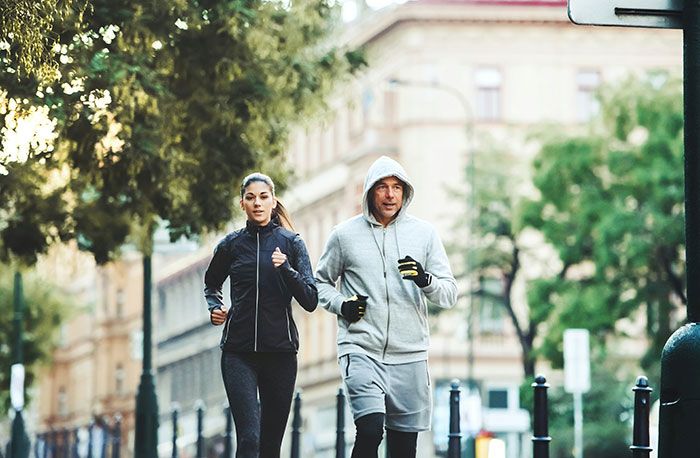 Pareja corriendo en la ciudad, símbolo de las señales de infidelidad que la gente pasó por alto en relaciones.