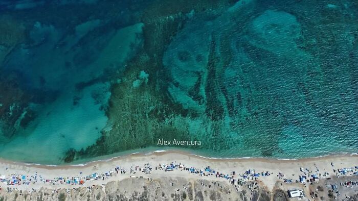 Vista aérea de un lugar misterioso y raro en la costa, descubierto en Google Earth con aguas turquesas y arena clara.