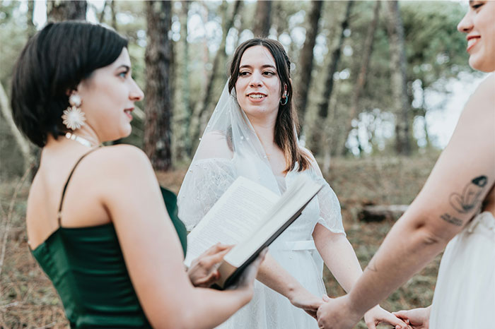 Novia con velo en ceremonia al aire libre mientras oficiante lee, reflejando historias sobre bodas que fueron de mal en peor.