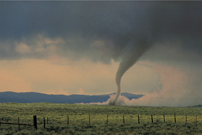 Tornado en el campo bajo cielo nublado simbolizando historias de bodas que fueron de mal en peor.