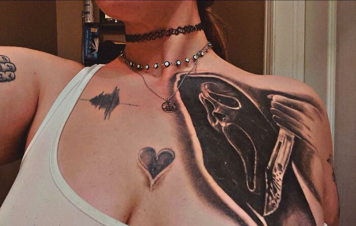 Tatuajes horribles en el pecho y hombro con diseños oscuros y un corazón, ejemplos de errores difíciles de borrar.