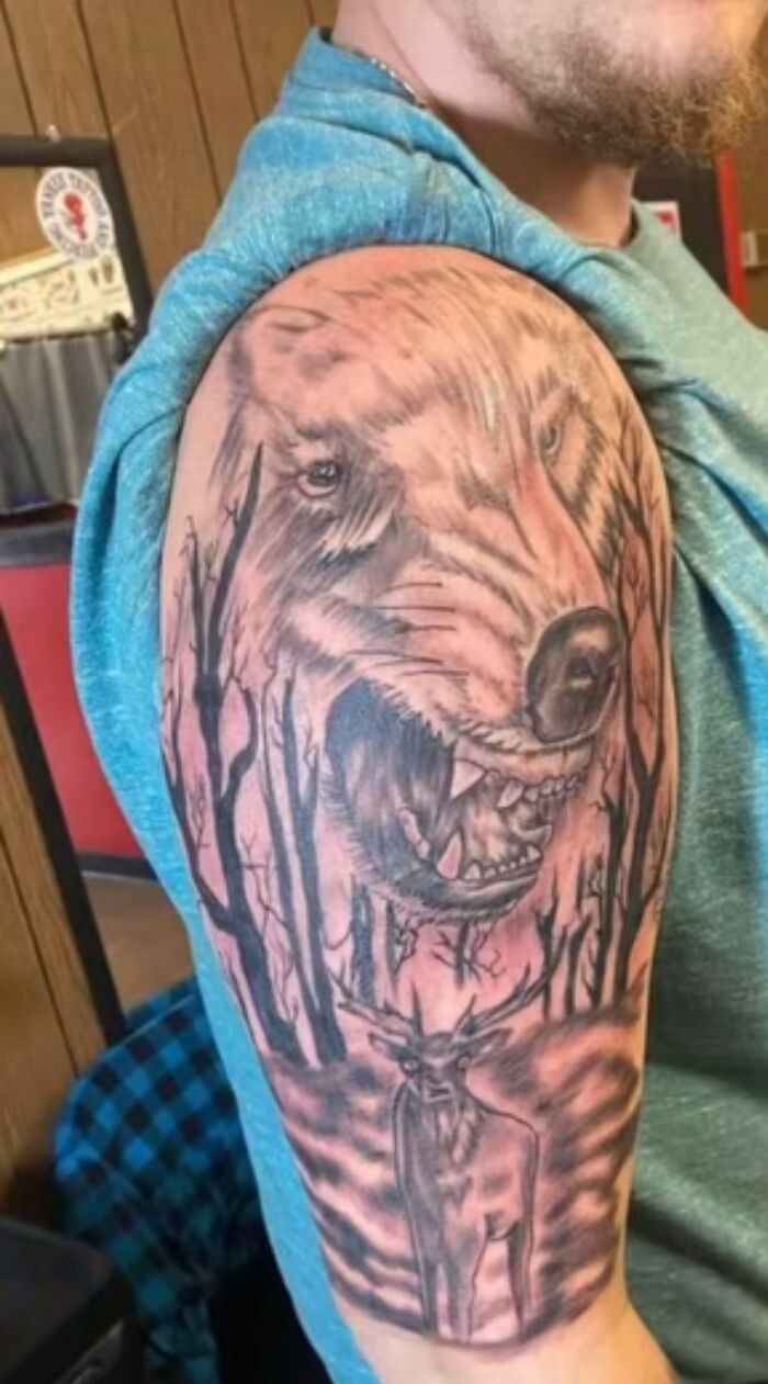 Tatuaje horrible en brazo con dibujo borroso de oso rugiendo y ciervo en bosque sombrío, ejemplo de errores difíciles de borrar.