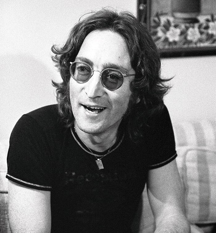 Hombre con gafas oscuras y cabello largo sonriendo en un entorno interior, celebridad relacionada con escándalos olvidados.