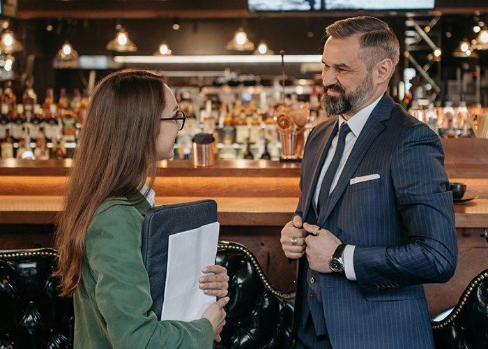 Camarero y cliente en restaurante, ilustrando citas terribles presenciadas por camareros en ambiente formal y elegante.