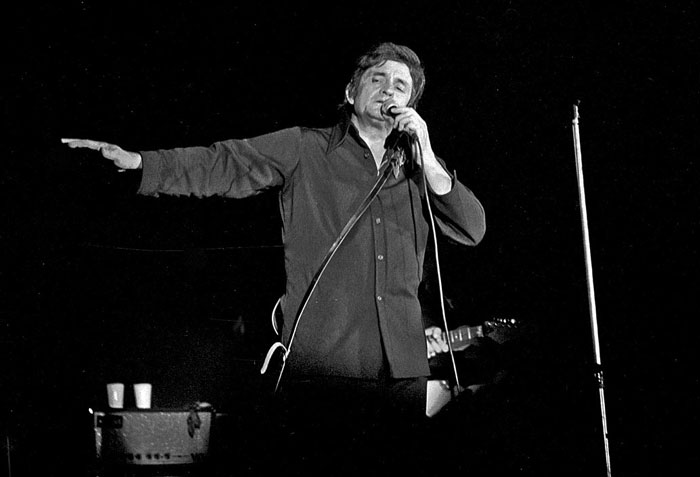 Cantante famoso en concierto en blanco y negro, representando a celebridades que hicieron algo horrible olvidado por el público.