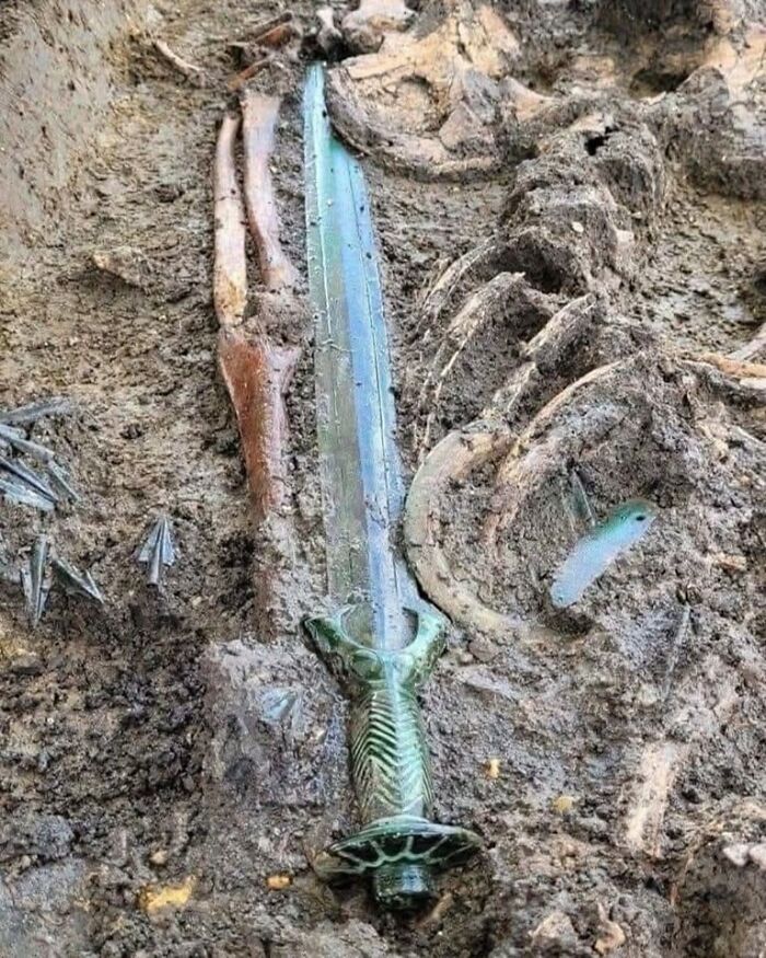 Espada antigua enterrada junto a restos óseos en un sitio arqueológico con increíbles descubrimientos arqueológicos.