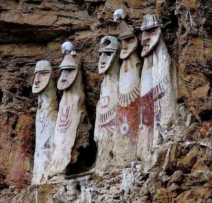 Figuras talladas en piedra con pinturas precolombinas, representando un descubrimiento arqueológico increíble en sitio rocoso.