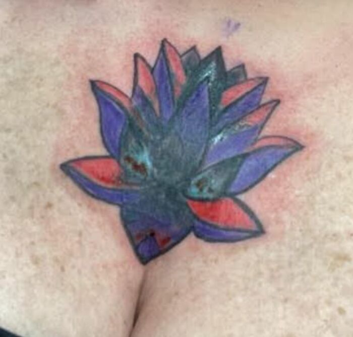 Tatuaje horrible de flor con colores mal combinados en el pecho que muestra uno de los errores difíciles de borrar.