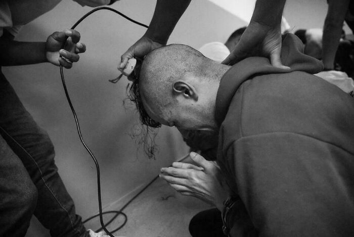 Persona con cabeza rapada a máquina, en escena inquietante y aterradora con tensión visible en blanco y negro.