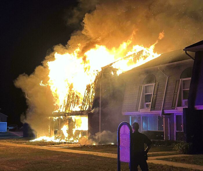 Casa en llamas durante la noche con fuego intenso, imagen aterradora y inquietante mostrando un incendio devastador.