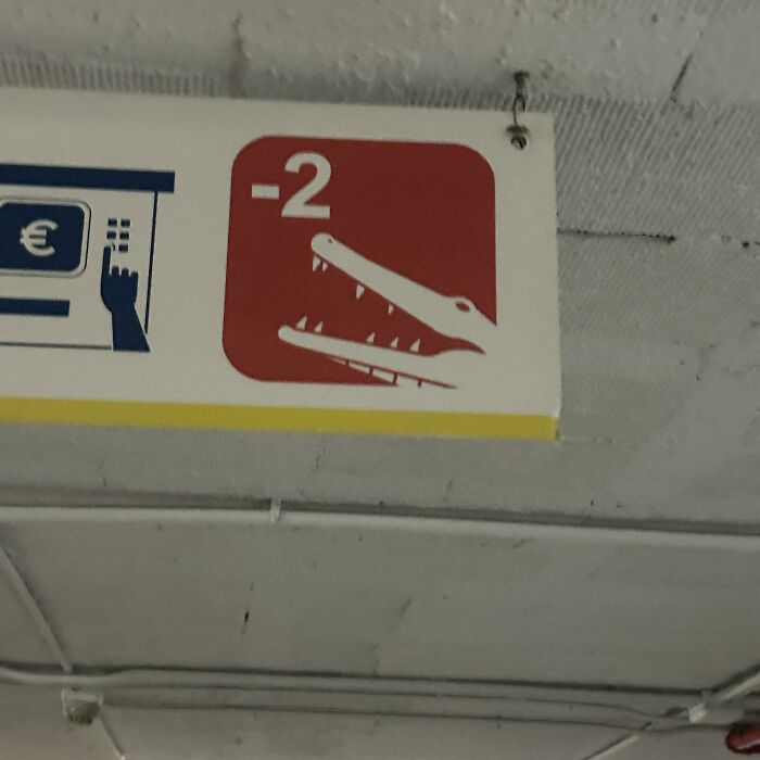Señal confusa con boca de cocodrilo y número -2 en estacionamiento que genera imágenes tan confusas como divertidas.