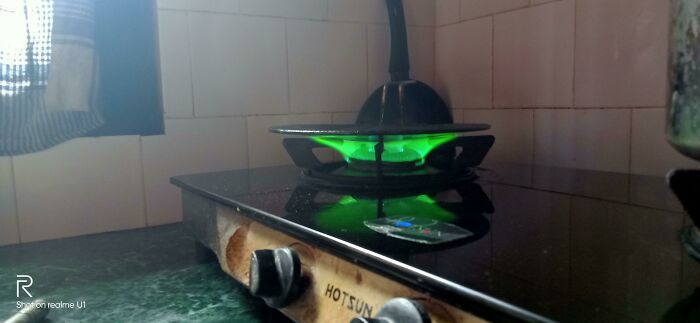 Estufa con fuego verde inusual, imagen confusa y divertida que destaca por su contexto curioso y poco común.