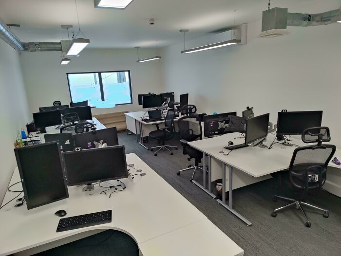Oficina vacía y desordenada con varias estaciones de trabajo mostrando un lugar de trabajo tóxico y poco saludable.