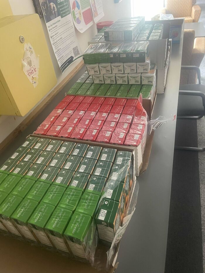 Cajas organizadas de jugos en un lugar de trabajo desordenado mostrando un ambiente tóxico y poco profesional.
