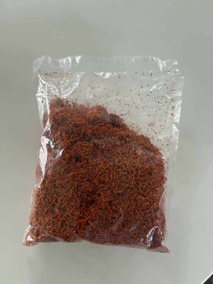 Bolsa de plástico transparente con contenido marrón que parece serrín o material extraño sin identificar.