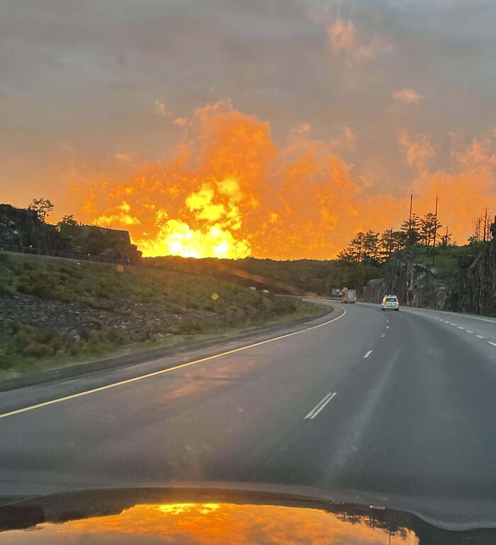 Atardecer en carretera con nubes naranjas que parecen una gran explosión, ejemplo de objetos interesantes que parecen otras cosas.