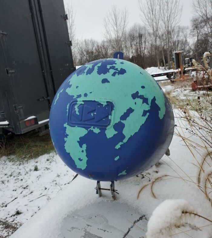 Esfera metálica con pintura que parece un mapa del mundo, mostrando un objeto interesante que parece otra cosa.