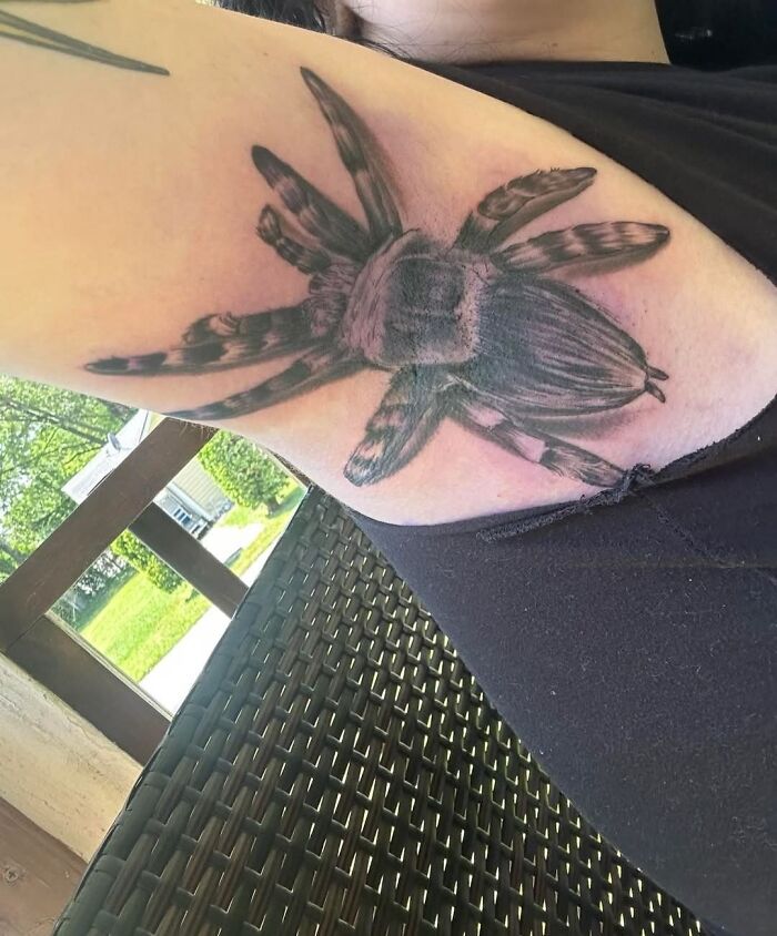 Tatuaje a color de araña grande en el brazo, ejemplo de tatuajes horribles difíciles de borrar.