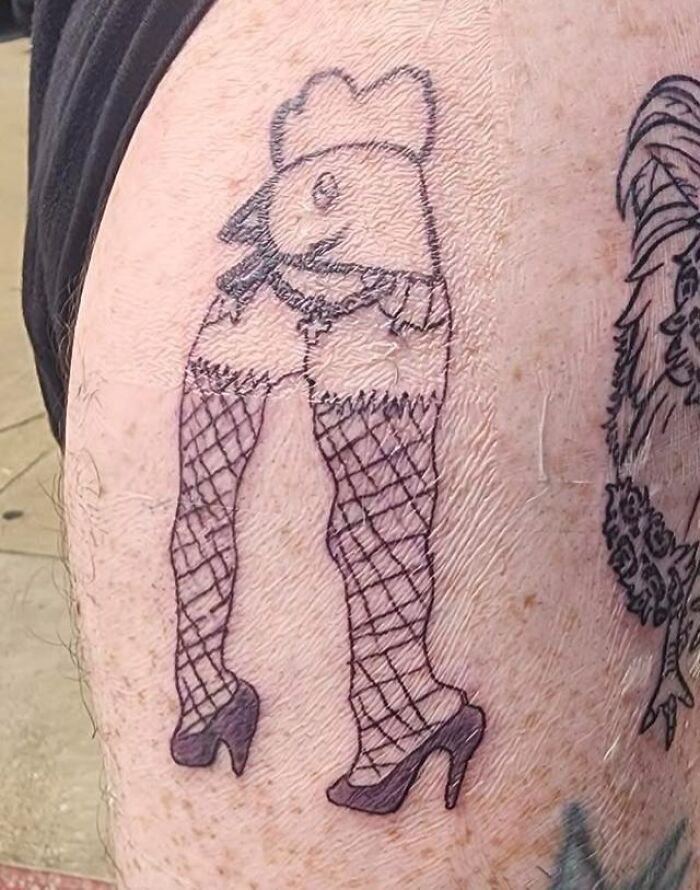 Tatuaje horrible de gallina con medias de red y tacones que muestra un error difícil de borrar en la piel.