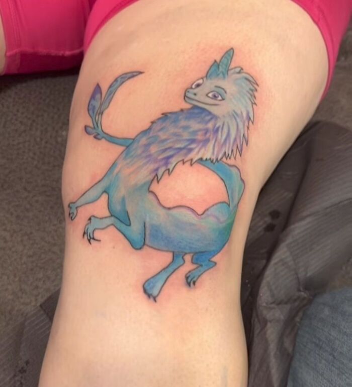 Tatuaje colorido de criatura fantástica en pierna, ejemplificando tatuajes horribles y errores difíciles de borrar en la piel.