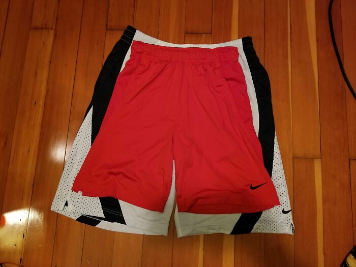 Imágenes comparativas de shorts deportivos en colores rojo, blanco y negro sobre piso de madera.