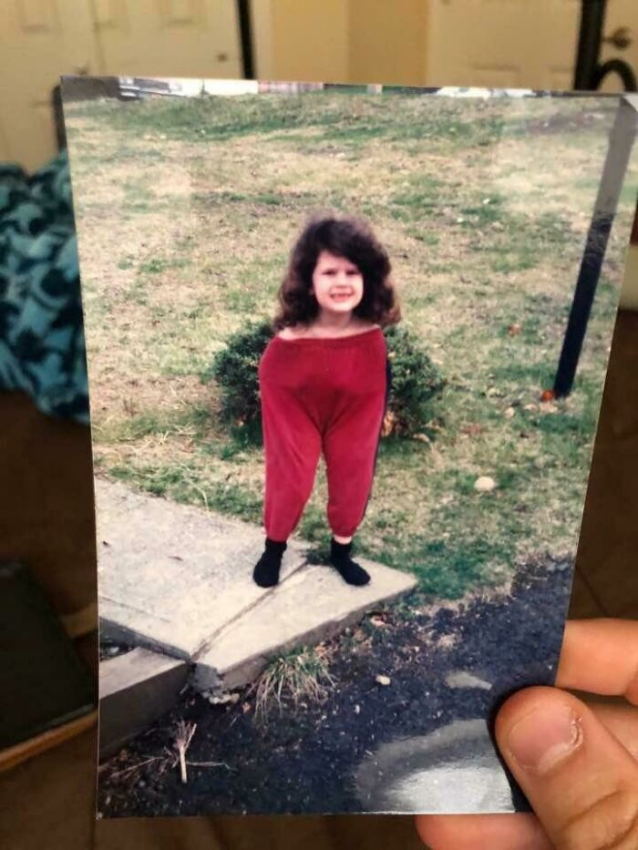 Niña con pantalones rojos grandes que parecen demasiado grandes, una imagen divertida para hacerte reír hoy.