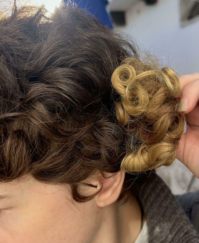 Comparación de mechones de cabello rizado en dos colores diferentes, mostrando contraste visual llamativo.