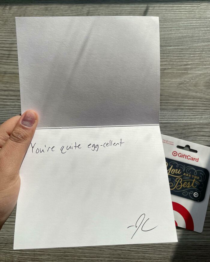 Mano sosteniendo una tarjeta con mensaje escrito a mano junto a una tarjeta de regalo, ejemplo de lugares de trabajo tóxicos.