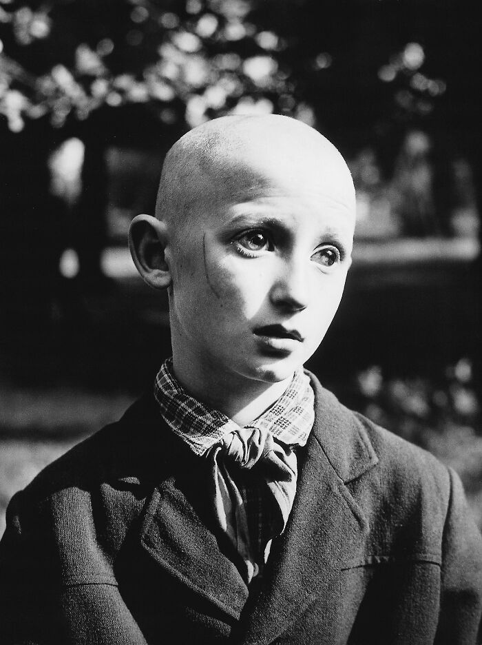 Retrato en blanco y negro de un niño con expresión inquietante, una foto antigua que refleja imágenes inquietantes del pasado.