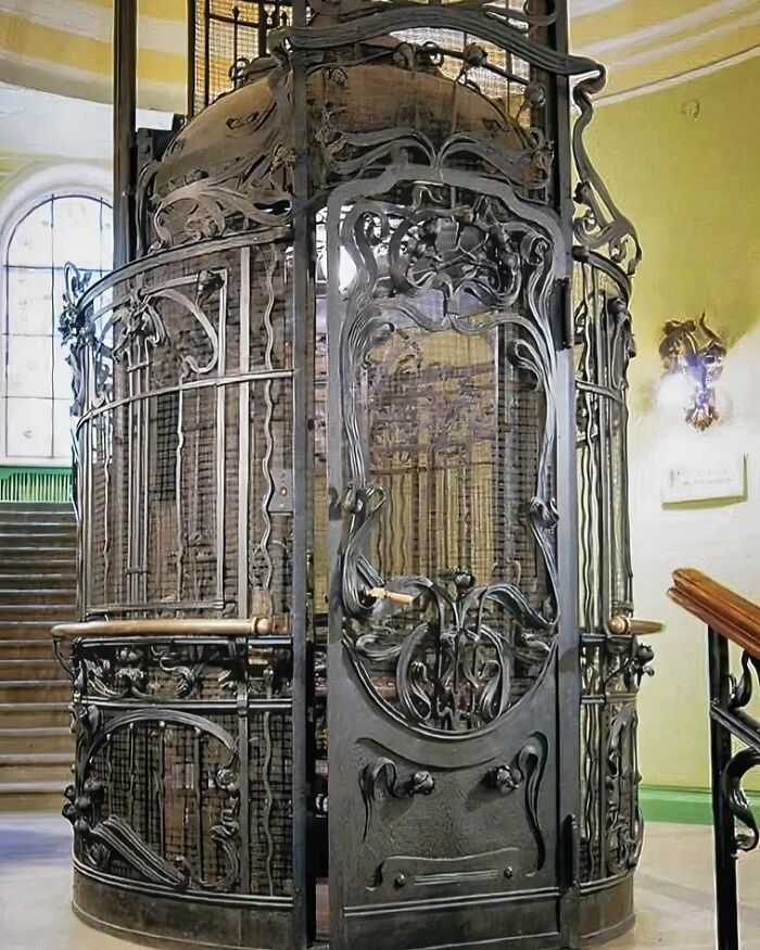 Ascensor antiguo con estructura de hierro forjado, ejemplo de increíbles descubrimientos arqueológicos en patrimonios históricos.