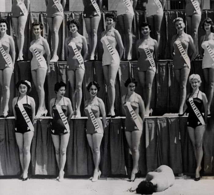 Mujeres con fajas representando países en concurso de belleza, foto inquietante en blanco y negro del pasado.