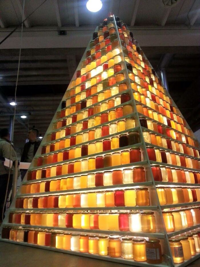 Estructura piramidal con cientos de frascos de diferentes colores mostrando una imagen comparativa única del mundo.