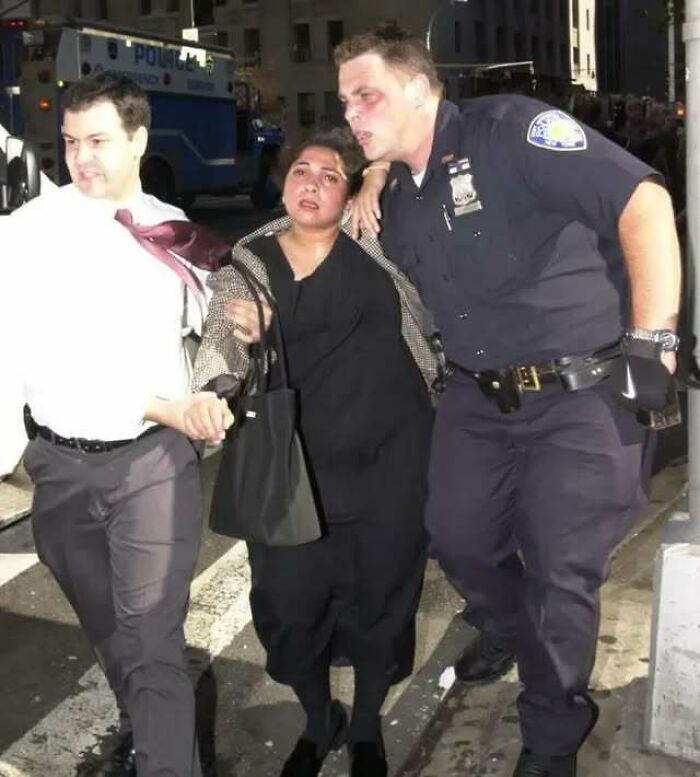 Mujer escoltada por policía y civil en una calle, imagen incluida en fotos históricas con curiosidades destacadas.