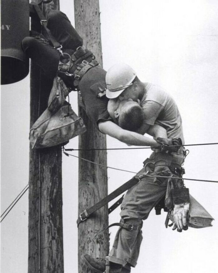 Trabajadores de electricidad en poste realizando rescate, foto histórica mostrando curiosidades de este oficio peligroso.